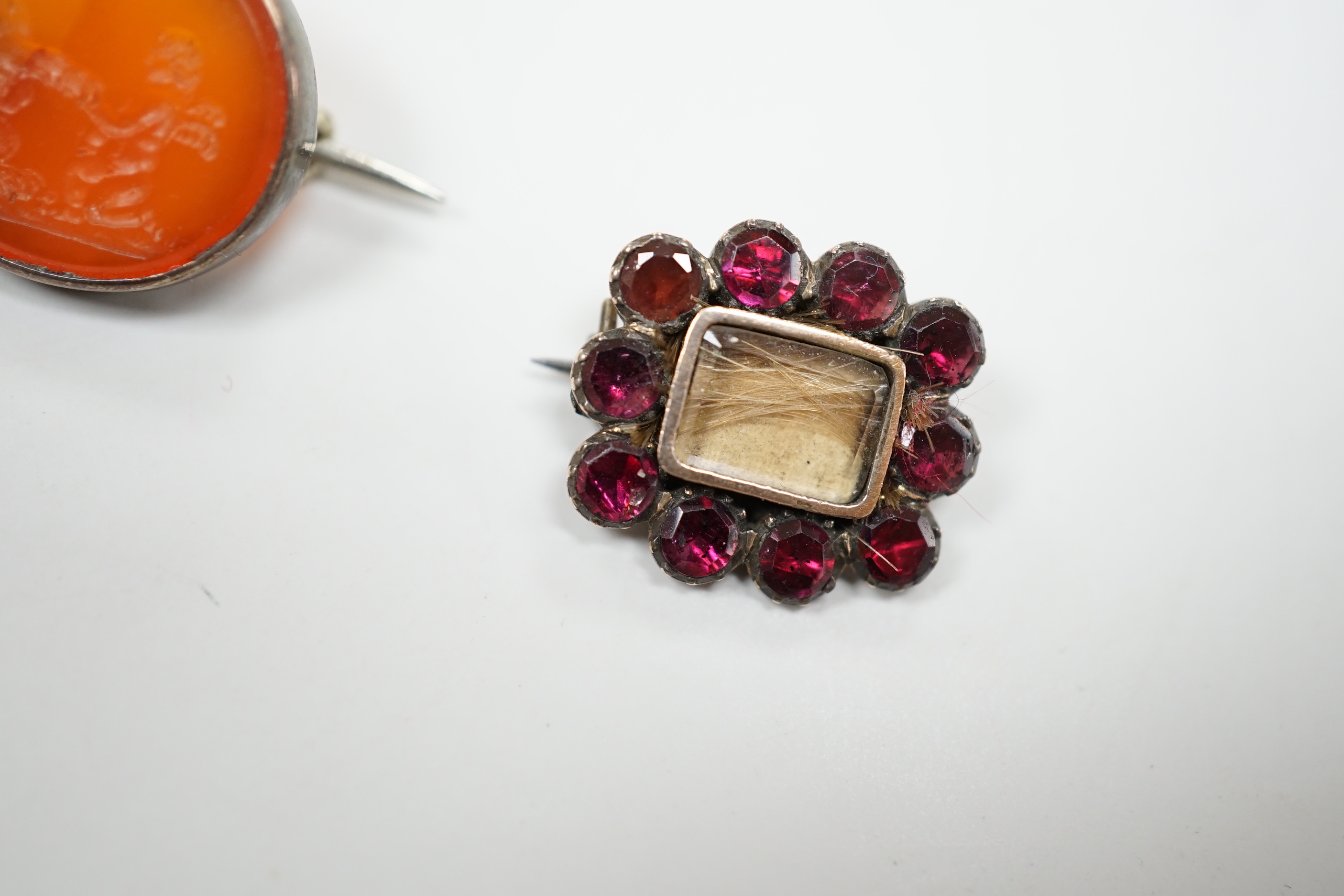 Five assorted antique brooches, comprising an early 19th century foiled ruby and hair work heart shaped brooch, 2.25cm, an early 19th century foiled garnet memorial brooch, 1.75cm, a Victorian unmarked gold oval brooch,